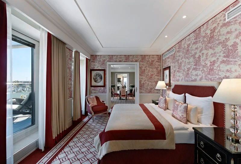 Luxuriöses Schlafzimmer mit rotem Dekor in der Opera Penthouse Suite im Hotel Sacher Wien.