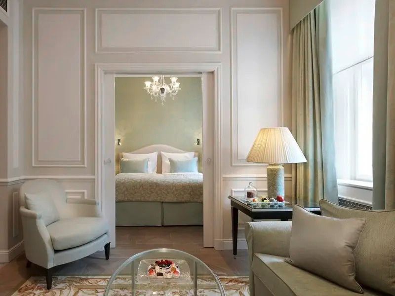 Suite mit gemütlichem Sitzbereich, Tischlampen und Blick ins Schlafzimmer