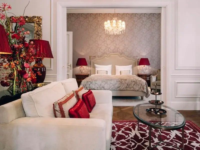 Elegant eingerichtetes Schlafzimmer mit großem Bett und Kronleuchter in der Suite.
