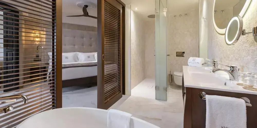 Offenes Badezimmer der Suite mit moderner Dusche und hochwertigen Armaturen.