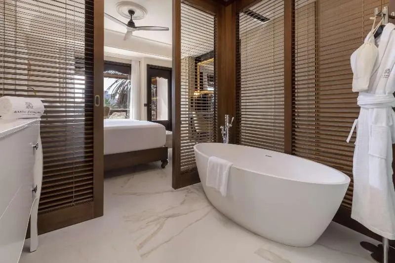Luxuriöses Badezimmer mit freistehender Badewanne und Blick ins Schlafzimmer