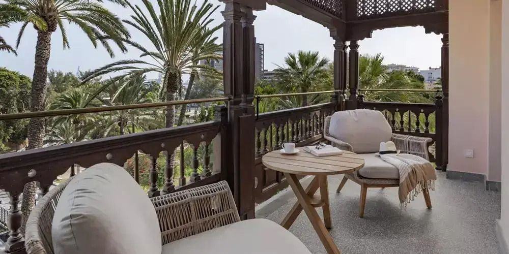 Privater Balkon der Präsidenten Suite mit gemütlichen Sitzmöglichkeiten und Palmengartenblick