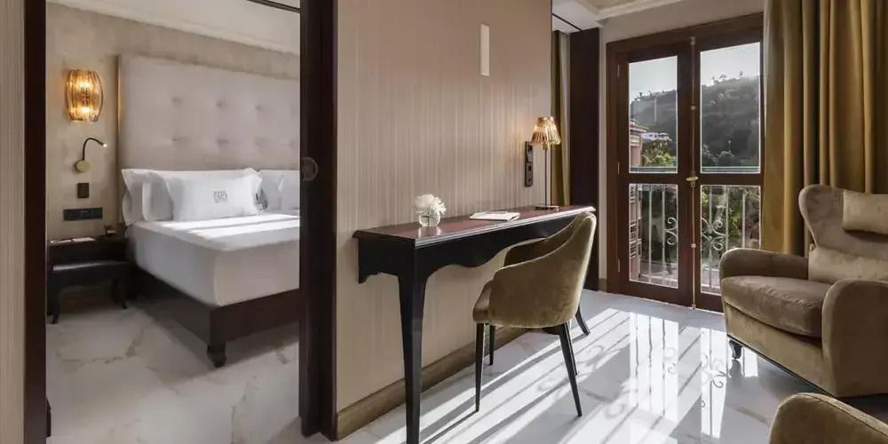 Arbeitsbereich mit Schreibtisch und Stuhl in einer luxuriösen Suite mit Balkon