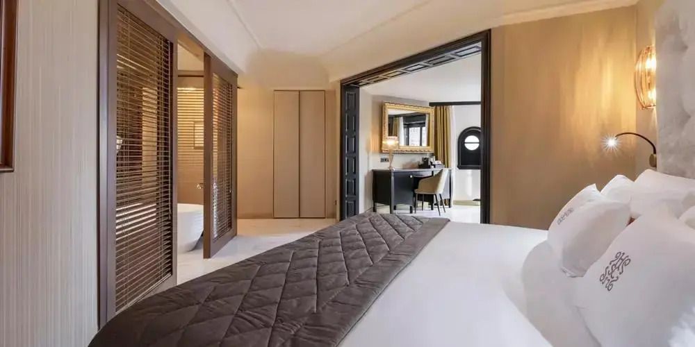 Elegantes Schlafzimmer mit Doppelbett und Blick in das Badezimmer in einer Premium Suite