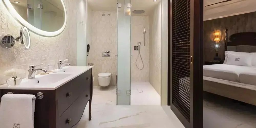 Modernes Badezimmer mit Regendusche und elegantem Waschtisch in der Suite