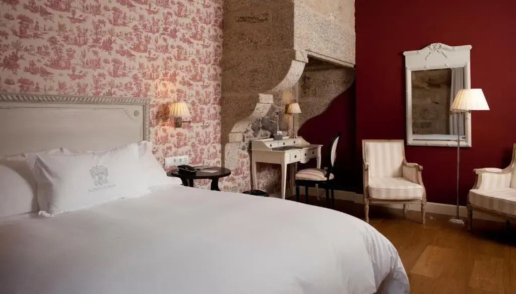 Elegant eingerichtetes Doppelzimmer mit Tapeten und antikem Schreibtisch