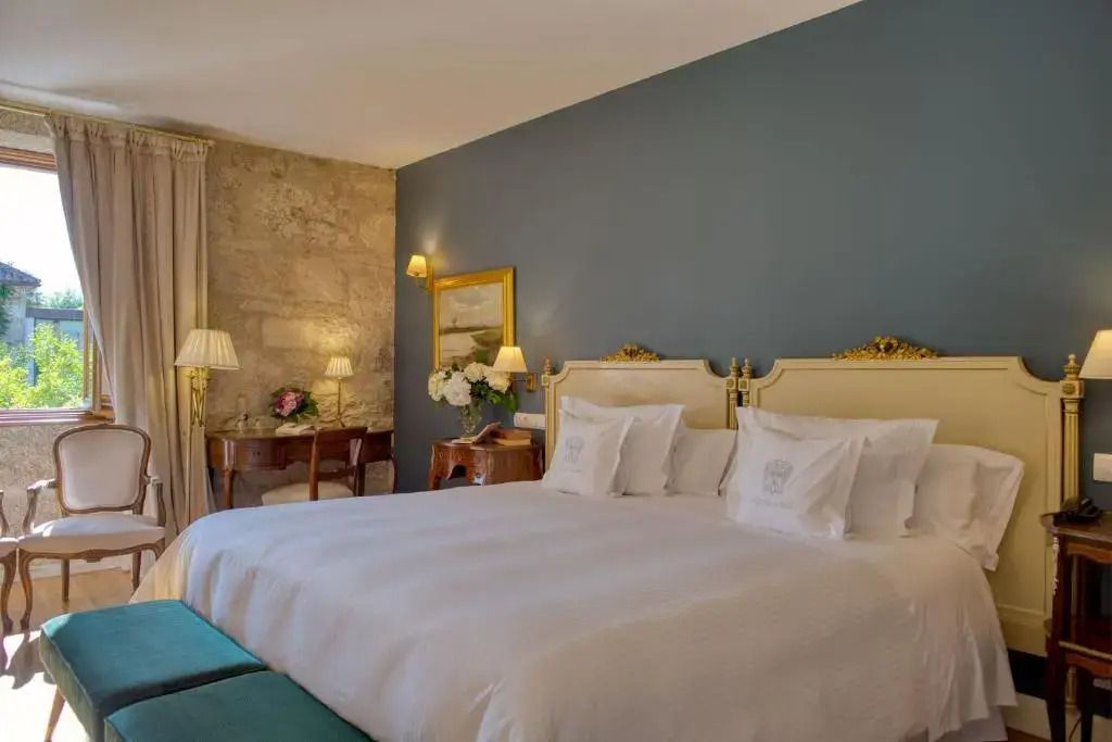 Geräumiges Zimmer mit Doppelbett und luxuriösen Details wie goldenen Nachttischlampen