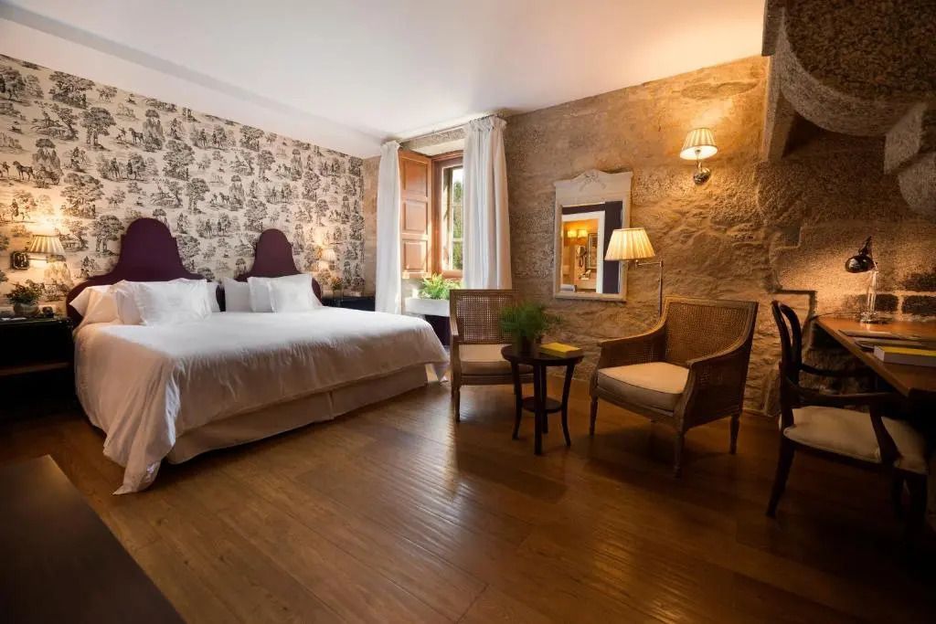 Helles Doppelzimmer mit Holzboden und rustikaler Steinwand