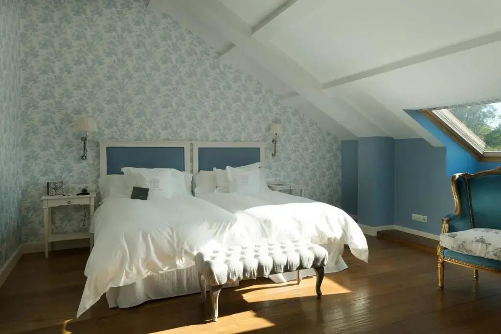 Dachzimmer mit zwei Betten und hellem Tageslicht