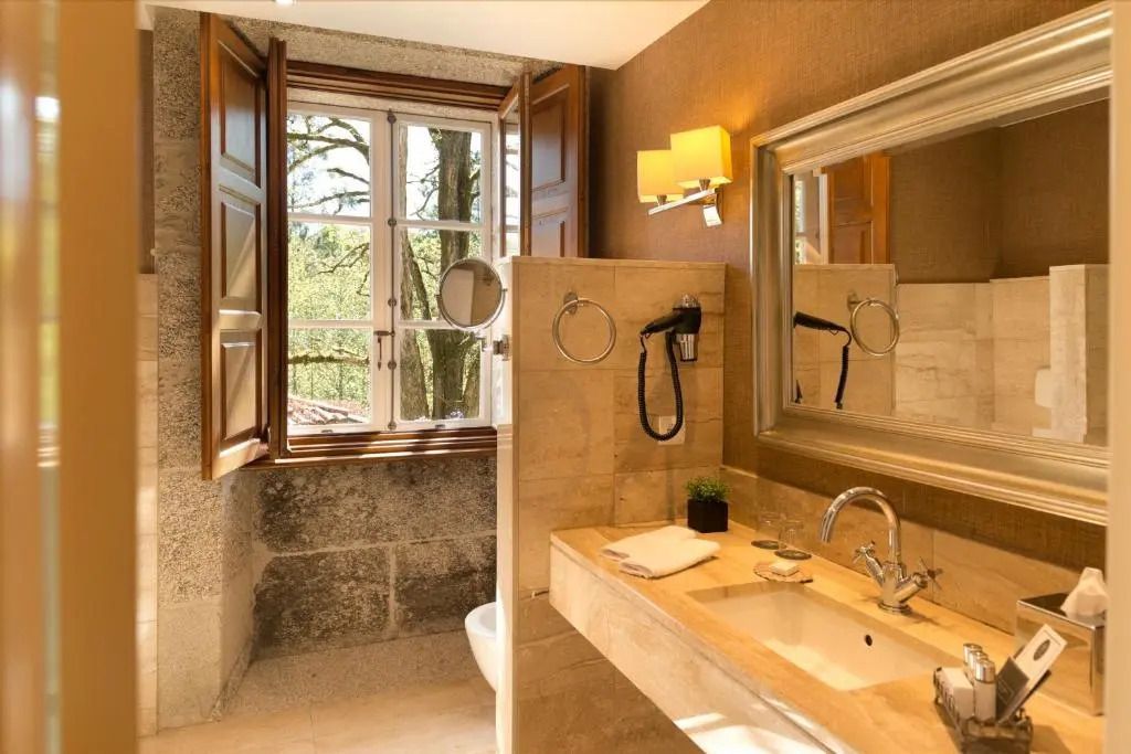 Badezimmer mit großem Fenster und eleganten Marmordetails