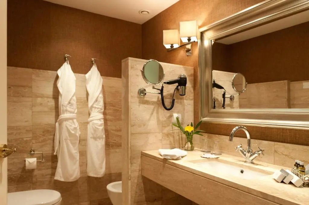 Elegantes Badezimmer im Hotel A Quinta da Auga mit großen Spiegeln und luxuriösen Details