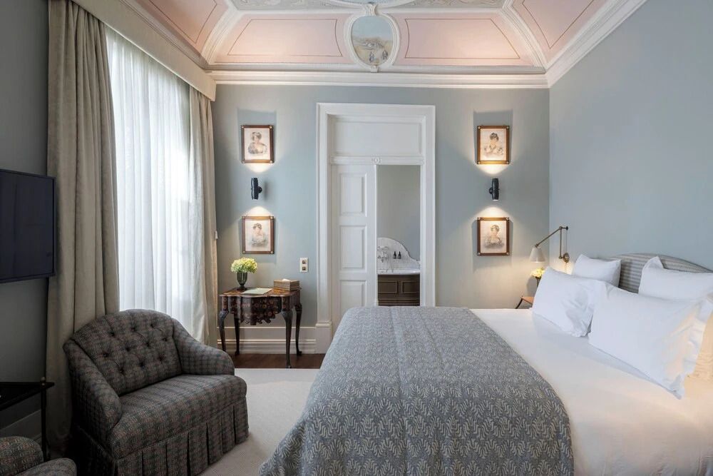 Elegantes Deluxe Doppelzimmer mit stilvollen Deckenverzierungen und gemütlicher Einrichtung.
