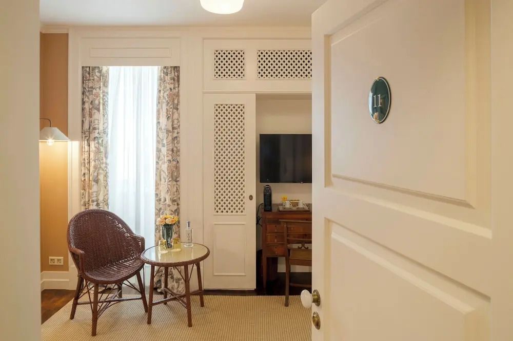 Offene Zimmertür mit Blick auf Sitzbereich und Fernseher im Deluxe Zimmer.