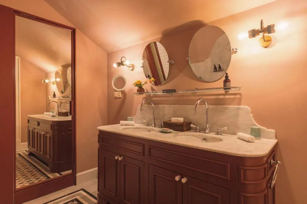 Luxuriöses Badezimmer mit Doppelwaschbecken und dekorativem Spiegel.