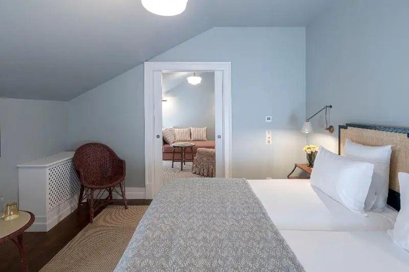 Helles Schlafzimmer mit Doppelbett und Zugang zu angrenzendem Wohnbereich