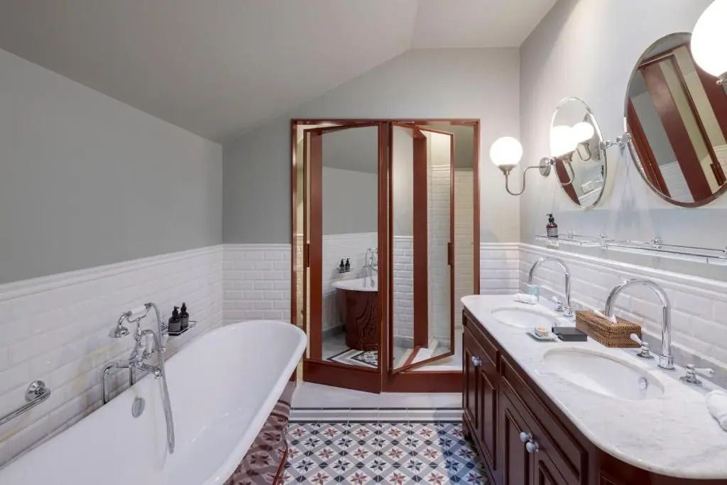 Charmantes Badezimmer mit Badewanne, Doppelwaschbecken und stilvollen Fliesen.