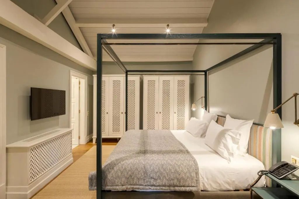 Suite mit Himmelbett, eleganter Beleuchtung und klassischem Dekor.