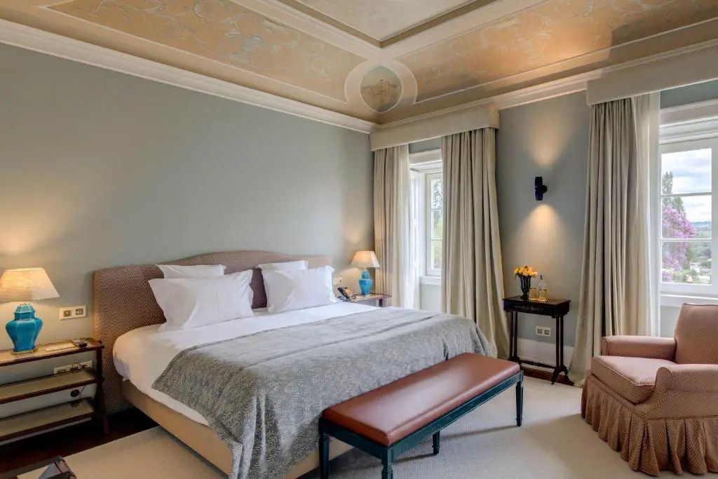 Gemütliches Schlafzimmer mit dekorativer Decke und großen Fenstern.
