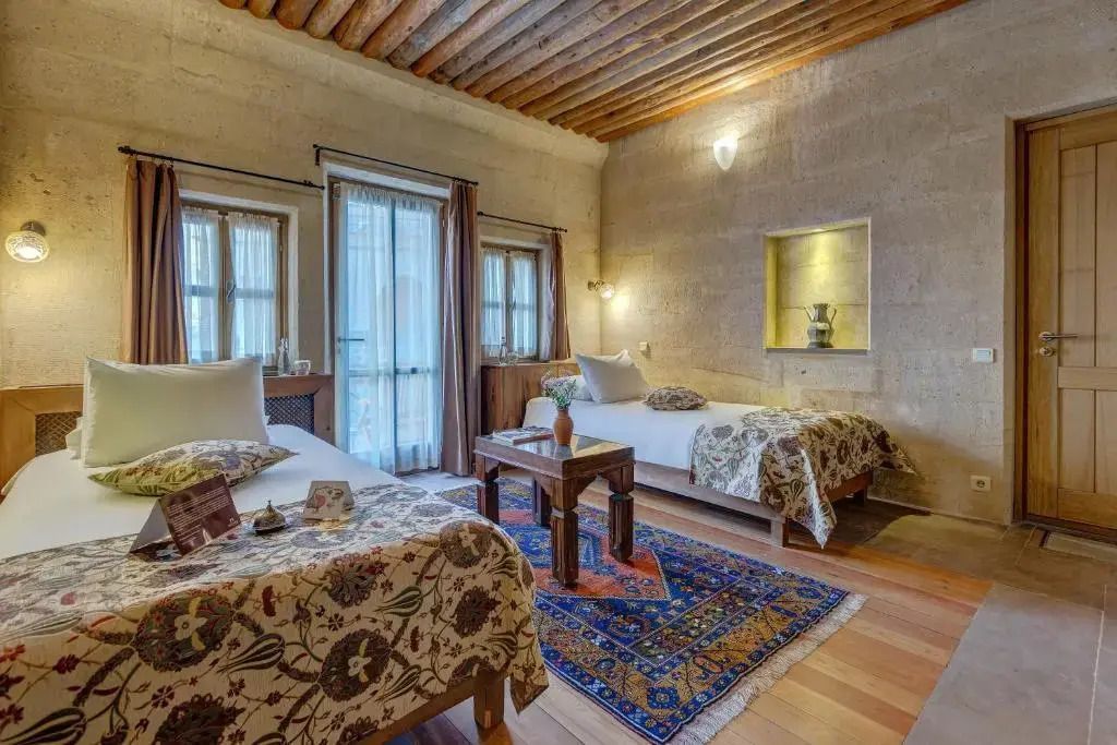 Gemütliches Deluxe Zimmer mit buntem Teppich und zwei Betten