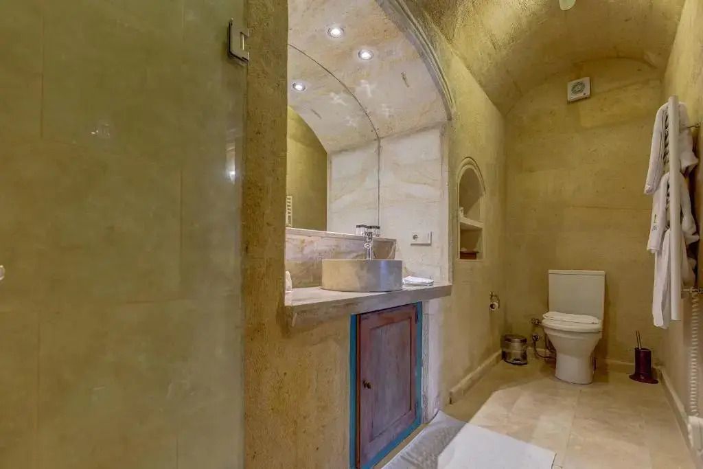 Badezimmer mit Waschtisch aus Naturstein und modernen Armaturen