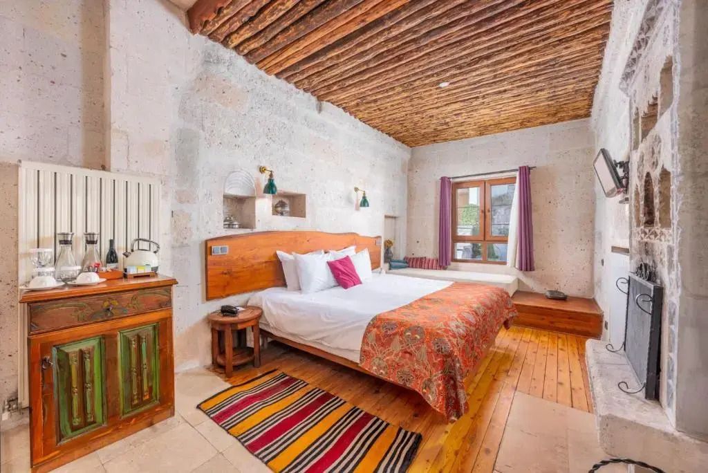 Gemütliches Zimmer mit Doppelbett, Holzboden und rustikalem Dekor