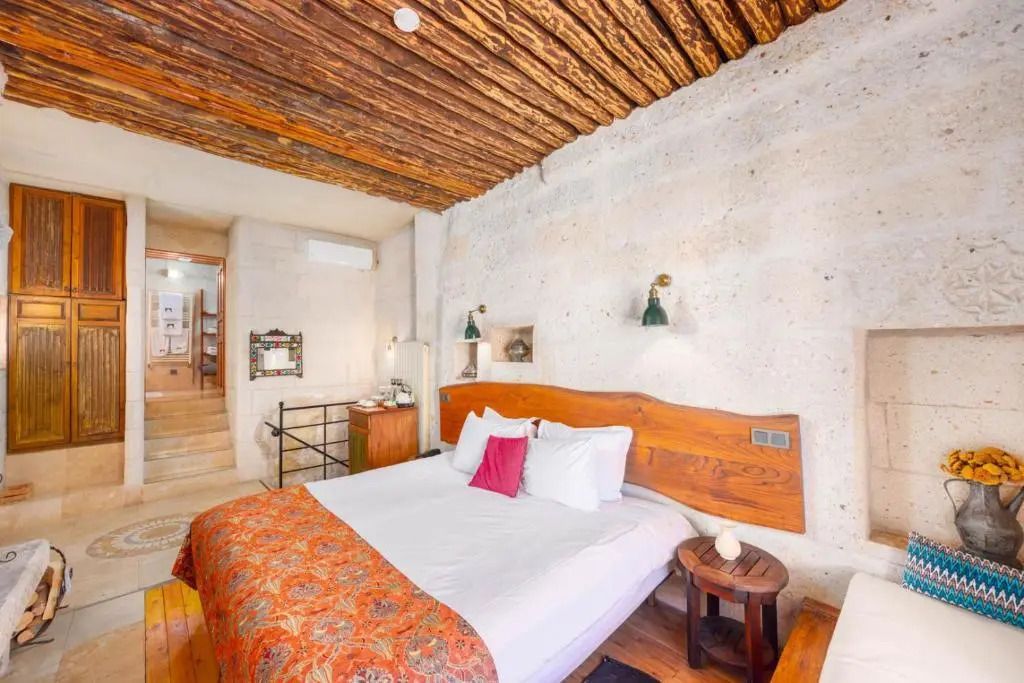 Schlafzimmer mit Doppelbett und Holzbalkendecke