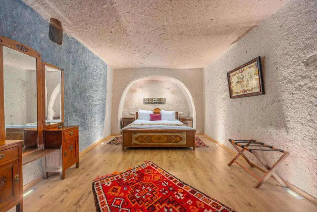 Gemütliches Schlafzimmer in Höhlenstil mit Doppelbett und rustikaler Einrichtung