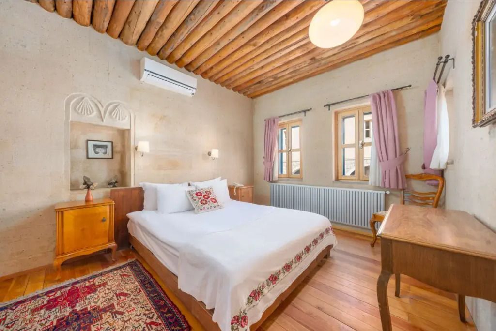 Gemütliches Schlafzimmer mit Holzbalkendecke und dekorativem Teppich im Royal Suite des Taskonaklar Hotels