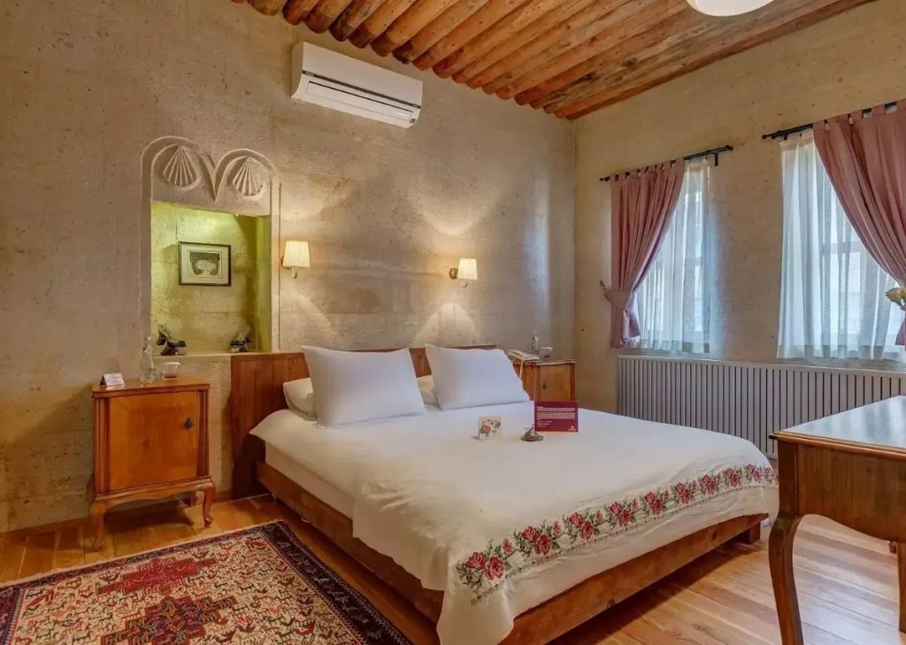 Dekoratives Schlafzimmer mit elegantem Bett und warmem Holzton im Royal Suite des Taskonaklar Hotels