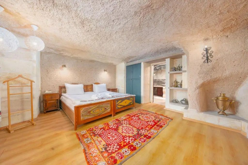 Höhlenzimmer mit Holzmöbeln und traditionellem Teppich im Taskonaklar Hotel