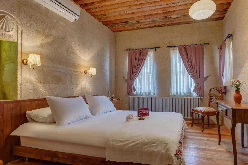 Gemütliches Schlafzimmer mit Holzbalkendecke und eleganter Einrichtung
