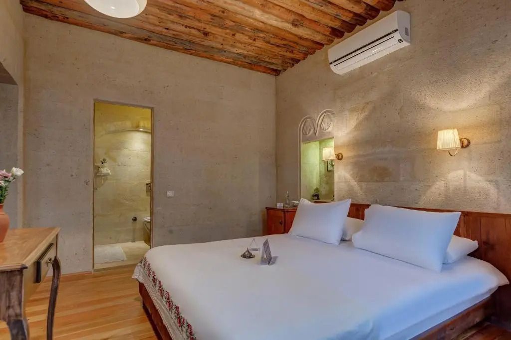 Geräumiges Schlafzimmer mit Natursteinwänden und modernem Badzugang