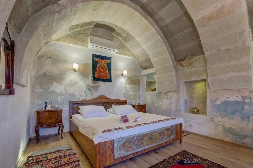 Steinbogen-Zimmer mit majestätischem Bett und historischem Flair