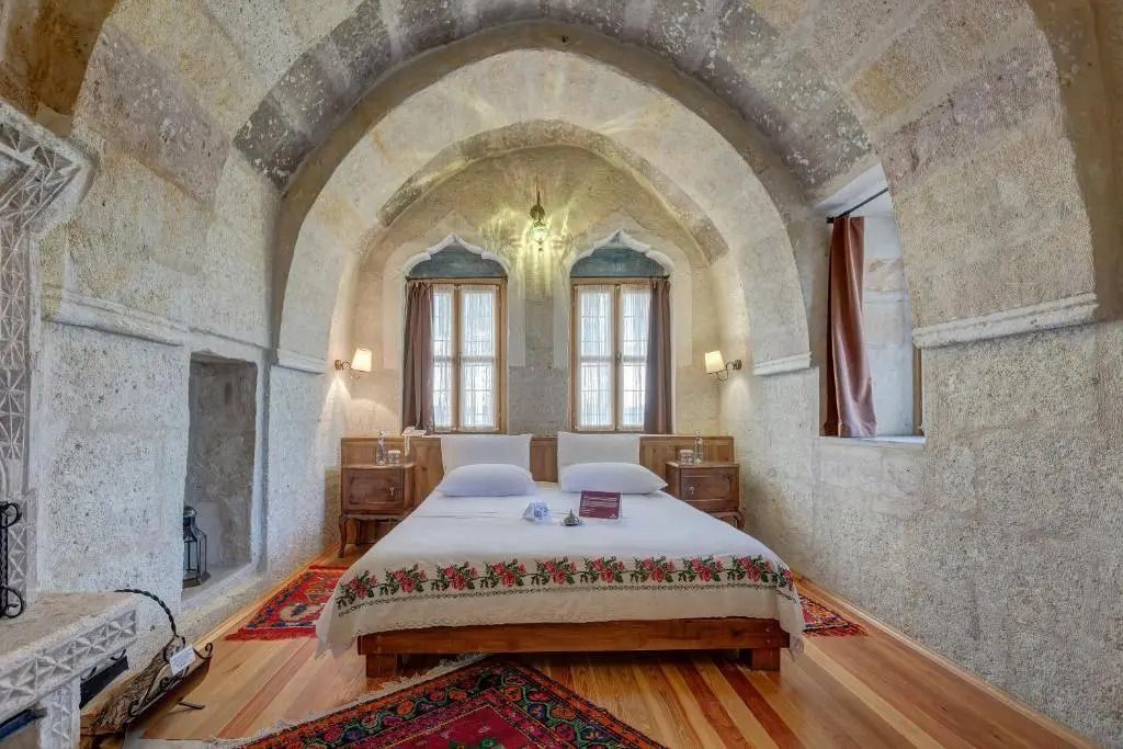 Helles Hotelzimmer mit gewölbter Decke, Doppelbett und traditionellen Elementen