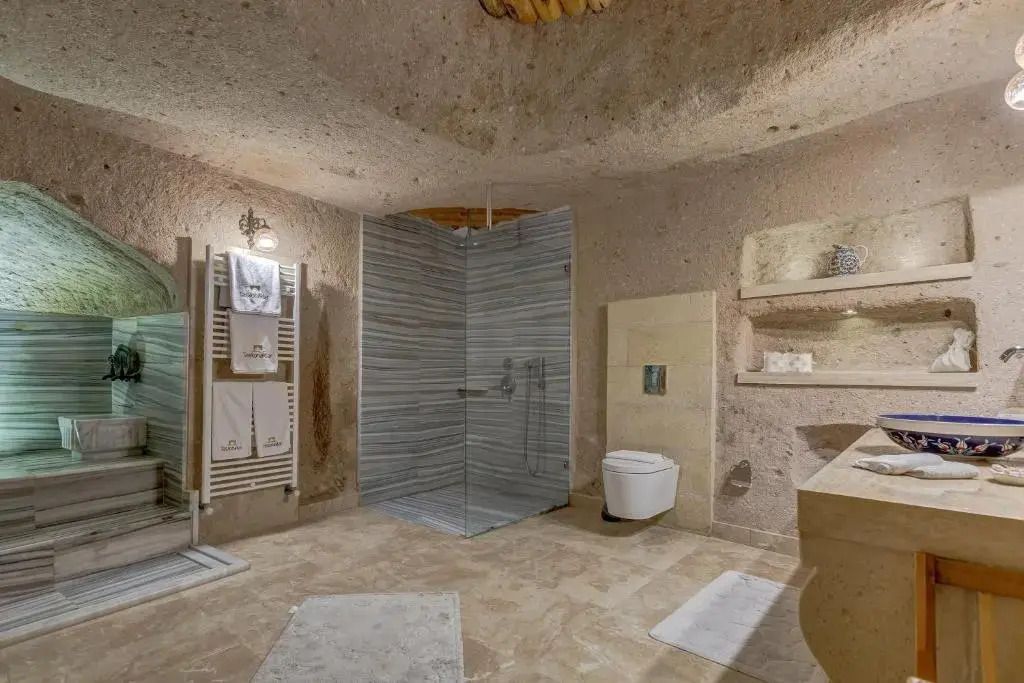 Badezimmer in Höhlenhotel mit geräumiger Dusche und natürlichem Stil