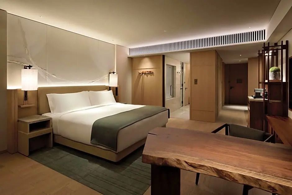 Luxuriöses Schlafzimmer in der Deluxe Doppel Junior-Suite mit elegantem Design und Stadtblick.