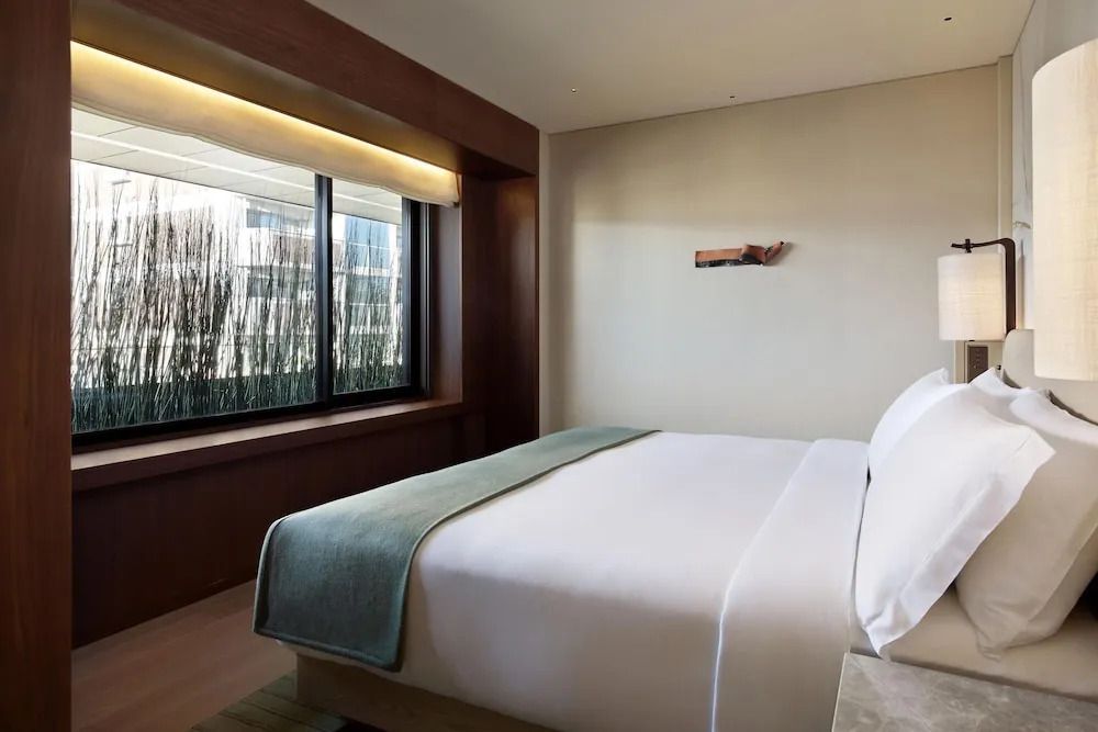 Komfortables Doppelbett in Deluxe Suite mit großem Fenster