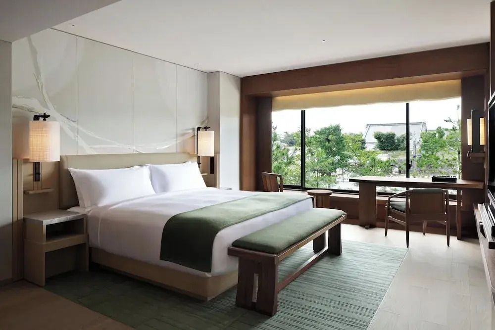 Modernes Bett mit grüner Tagesdecke in der Suite