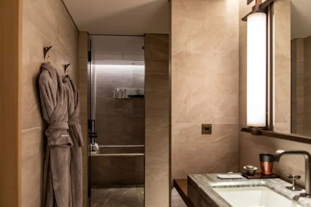 Elegantes Badezimmer mit Badewanne und weichen Bademänteln im Hotelzimmer.