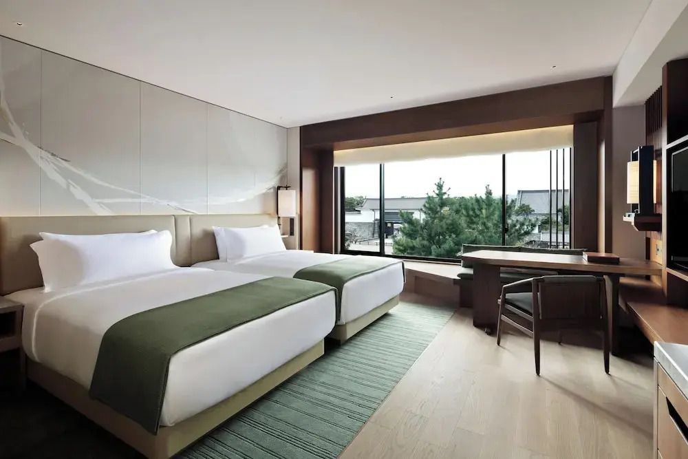 Standard Doppelzimmer mit zwei Betten, großem Fenster und Schreibbereich
