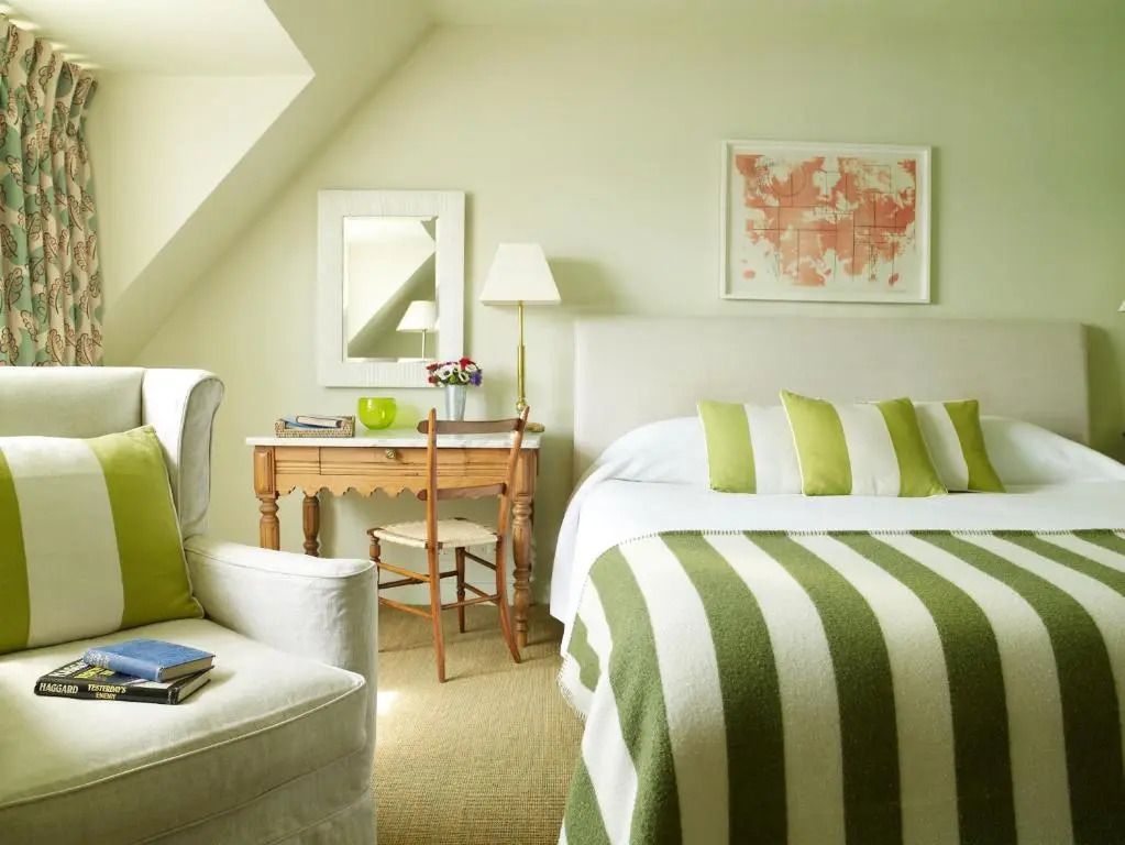 Deluxe Doppelzimmer mit grün gestreiften Kissen und gemütlicher Sitzgelegenheit