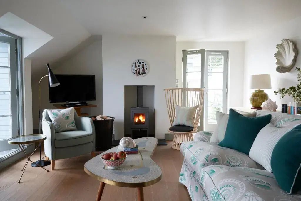 Gemütliches Wohnzimmer der Deluxe Suite mit modernem Kamin und stilvollen Möbeln