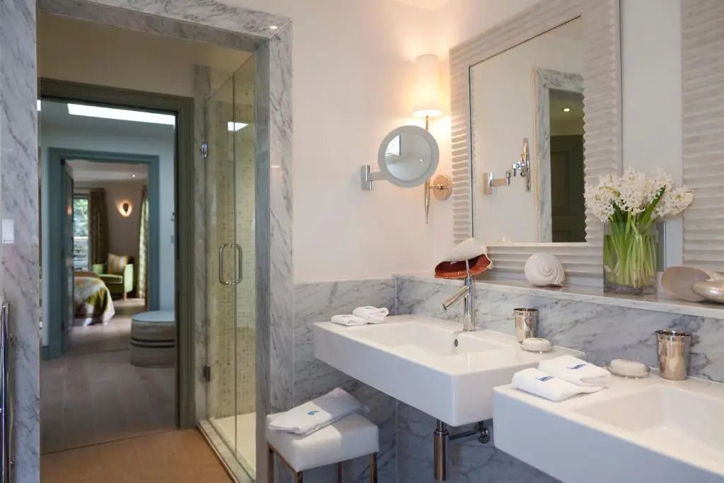 Modernes Badezimmer der Deluxe Suite mit geräumiger Dusche und Marmordetails
