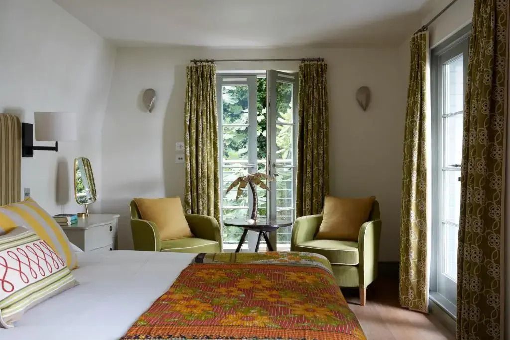 Helles Schlafzimmer der Deluxe Suite mit großen Fenstern und eleganter Einrichtung