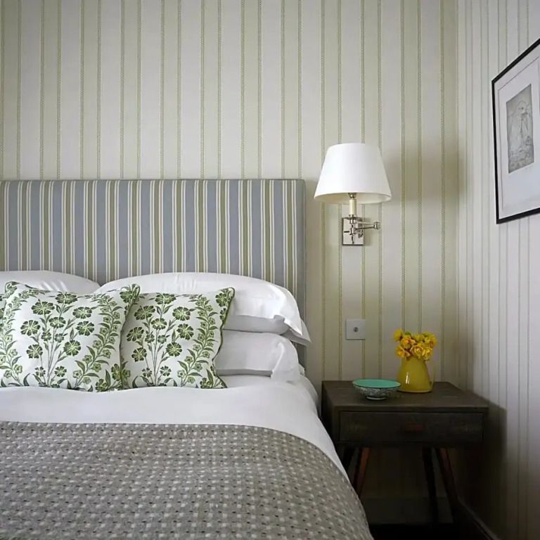Elegantes Doppelzimmer mit gestreifter Tapete und gemütlichen Kissen