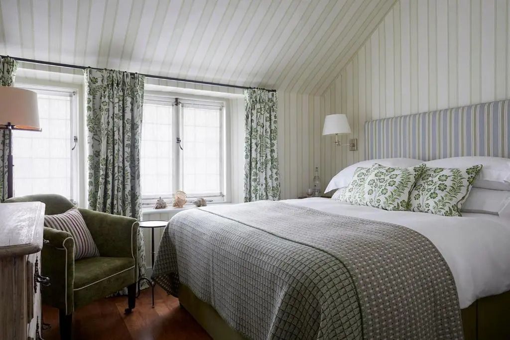 Gemütliches Zimmer mit weiß-grüner Einrichtung und Fenster
