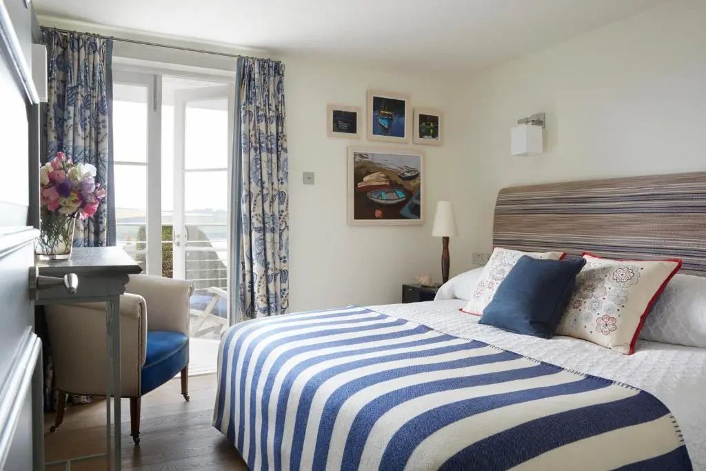 Helles Schlafzimmer der Suite mit Meerblick und stilvollen Bettbezügen
