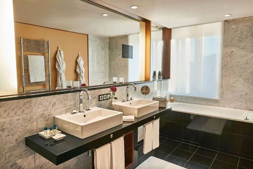 Modernes Badezimmer mit zwei Waschbecken, Badewanne und stilvollen Details.