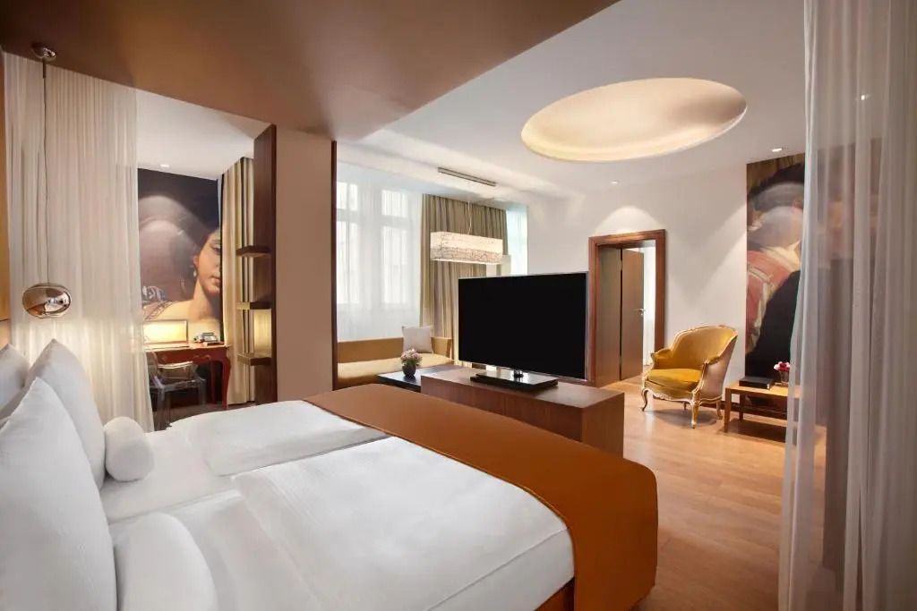 Geräumige Junior-Suite mit Doppelbett, stilvolle Einrichtung, Holzböden und Kunstwerke.