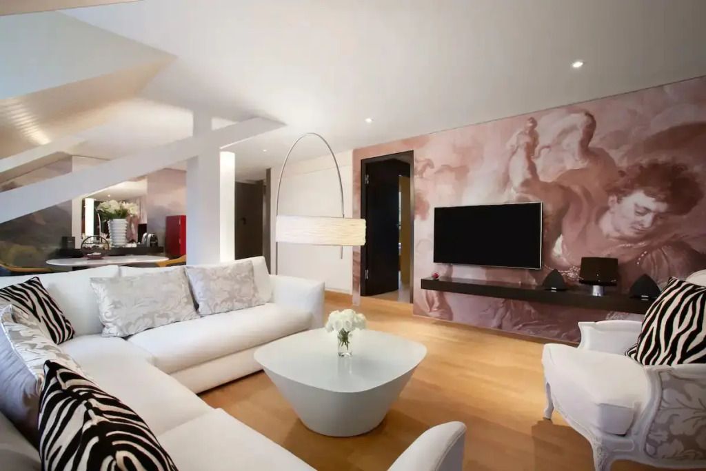 Modernes Wohnzimmer mit gemütlicher Sofalandschaft und TV in der Suite.